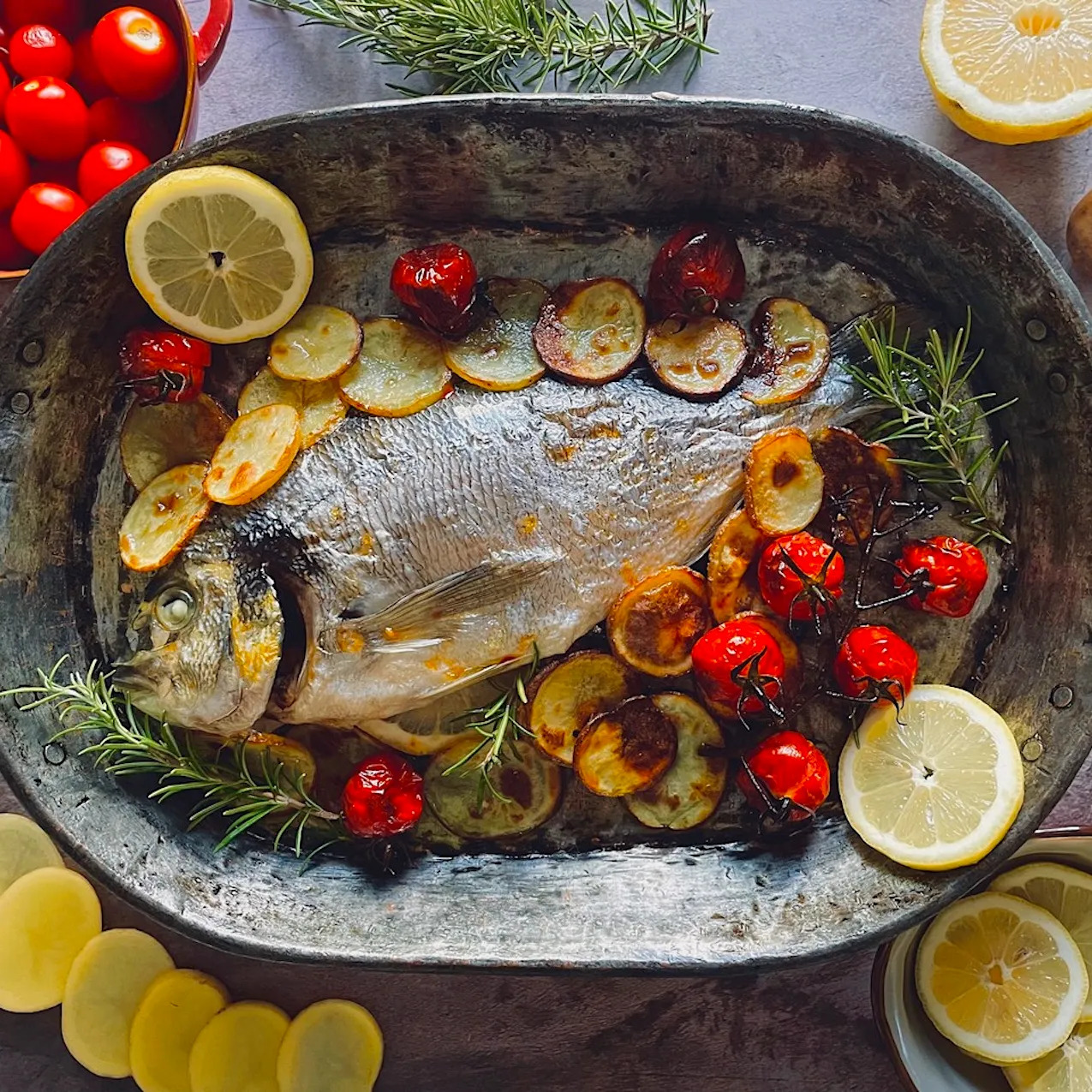 Orata al forno con patate, pomodorini e profumo di agrumi